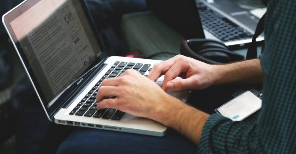 A programmer typing on a laptop in an indoor setting, showcasing technology in use.