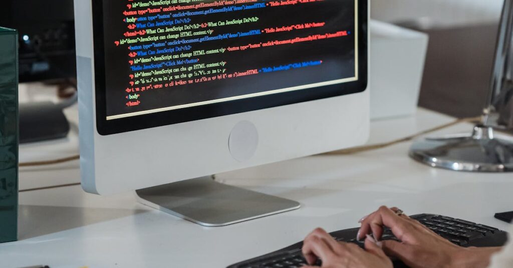 Close-up of a person typing code on a computer in an office setting.