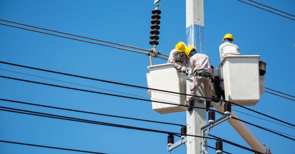 Electricians wearing safety gear work on power lines in Nakhon Ratchasima, Thailand.