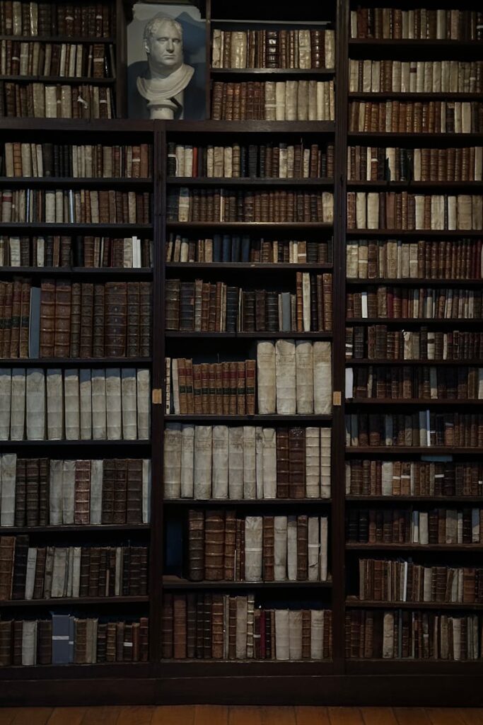 A classic library with antique books and a bust, displaying a timeless intellectual ambiance.