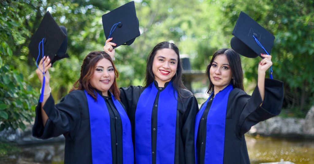 Three female graduates in gowns and caps celebrating outdoors, showing achievement and joy.
