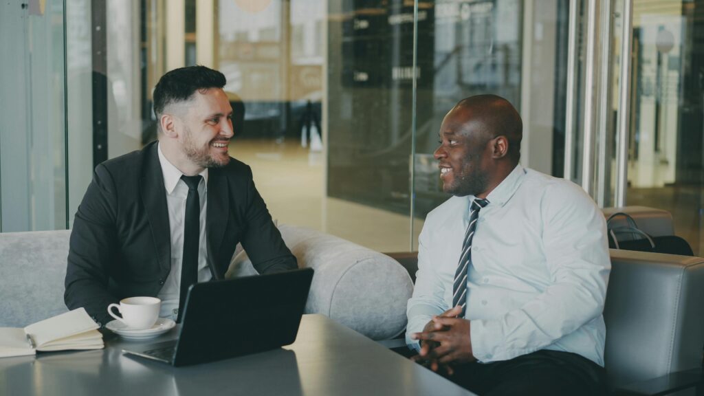 Two businessmen engaged in a professional meeting in a modern office environment.