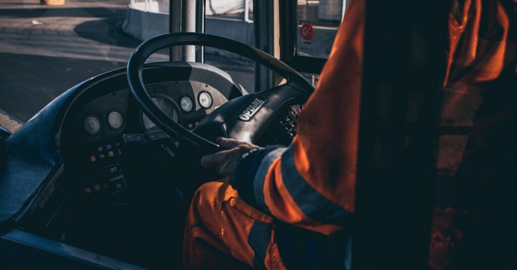 Bus driver operating vehicle from the cockpit in an industrial setting, showcasing control and focus.
