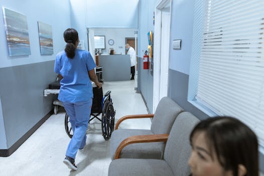 Scholarships A nurse in scrubs pushes a wheelchair through a well-lit hospital corridor, attending to patient care.