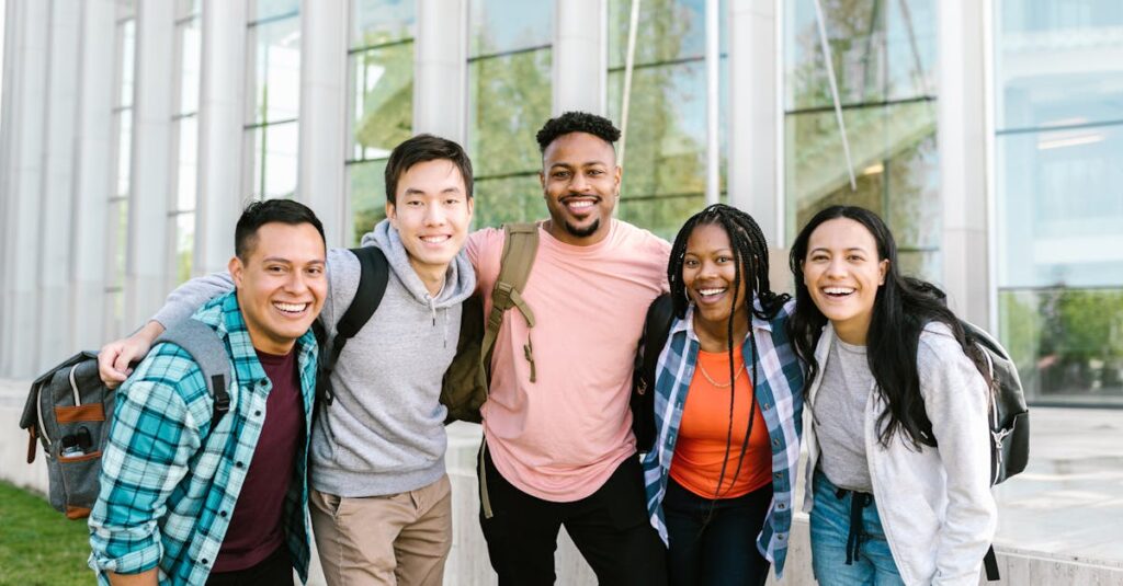 Tuition & Aid A diverse group of young adults smiling and standing together in front of a modern glass building.