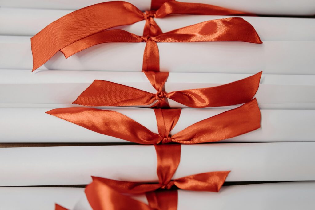 Scholarships Close-up of graduation diplomas tied with vibrant red ribbons, symbolizing achievement and success.