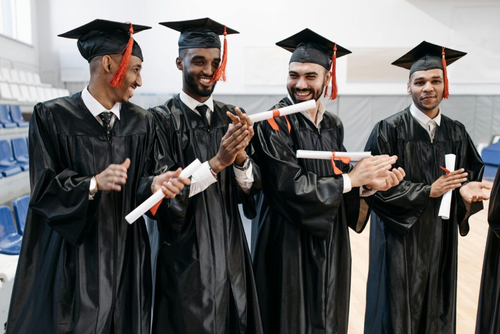Joyful graduates in caps and gowns celebrating their achievement indoors.