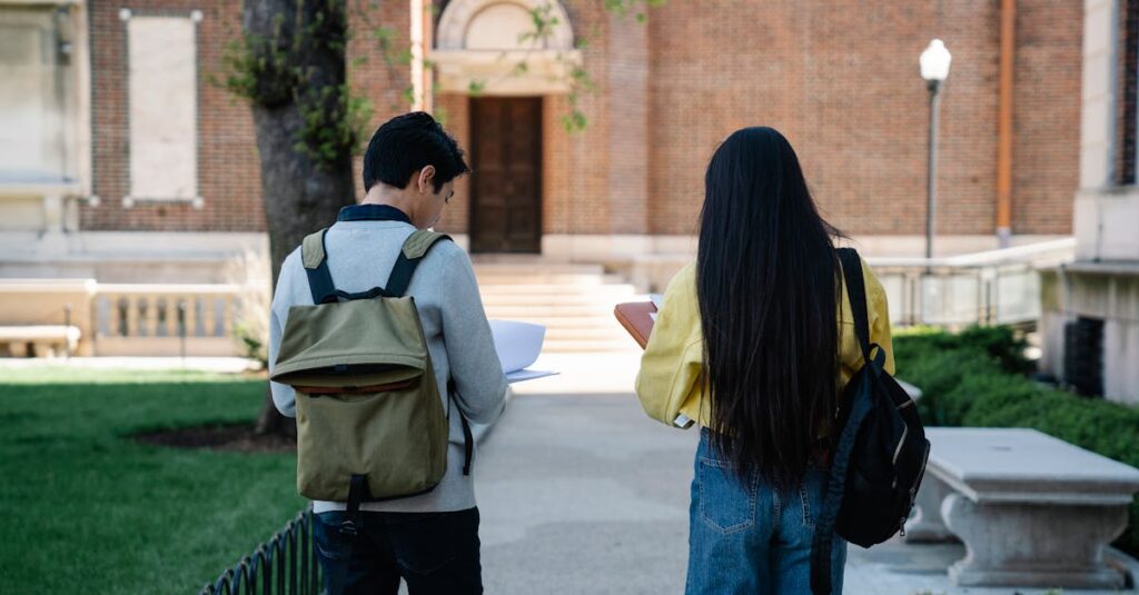 Tuition & Aid Two college students with backpacks walking near a university building.