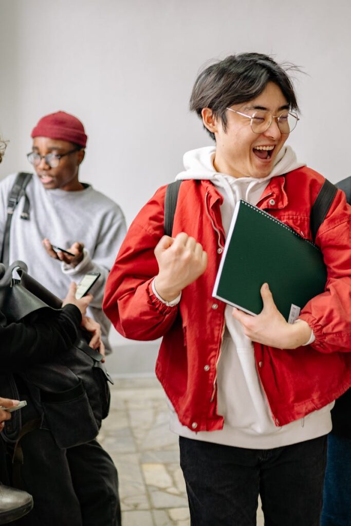 A group of diverse college students happily interacting indoors, showcasing friendship and diversity in a university setting.