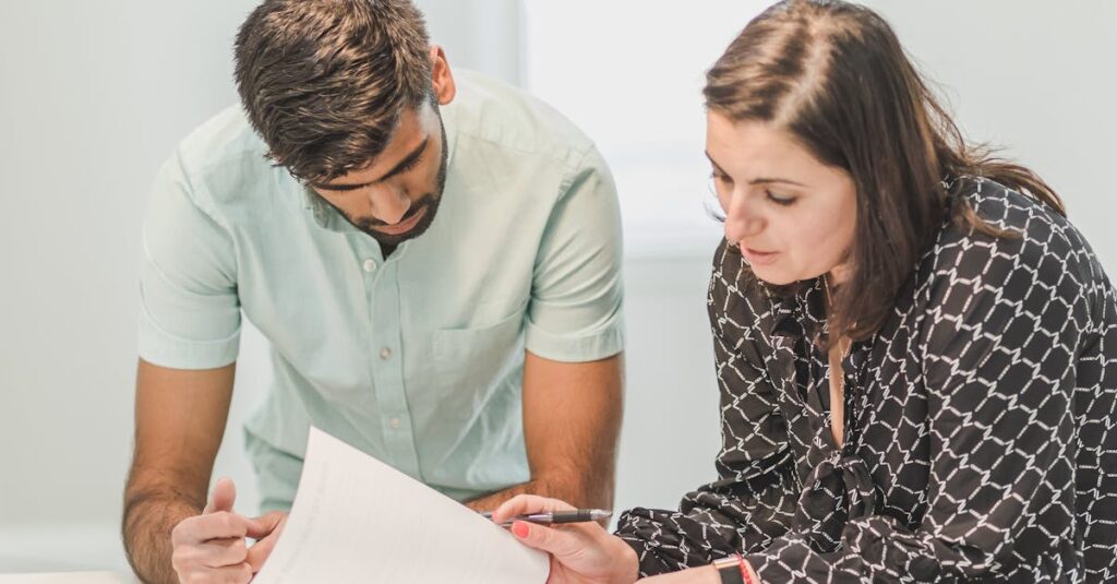Real estate agent assisting first-time homebuyer with documents inside a bright room.