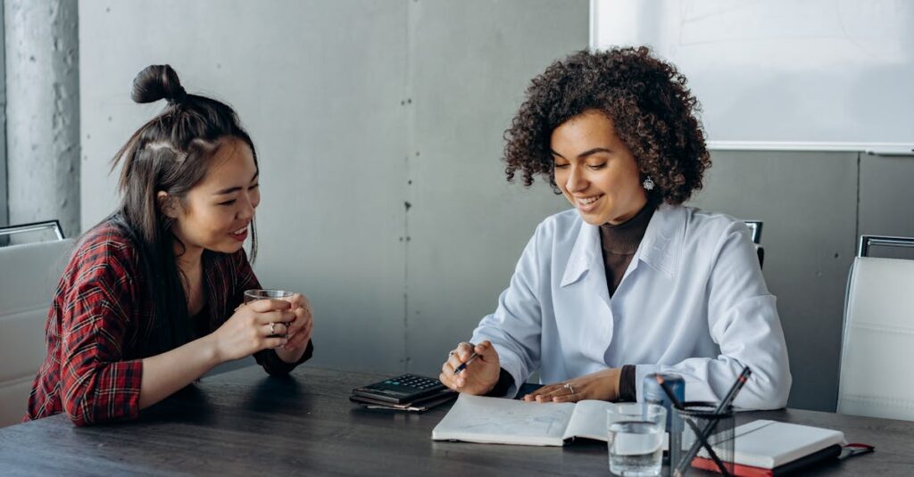 Two women in a modern office setting engaging in a collaborative discussion.